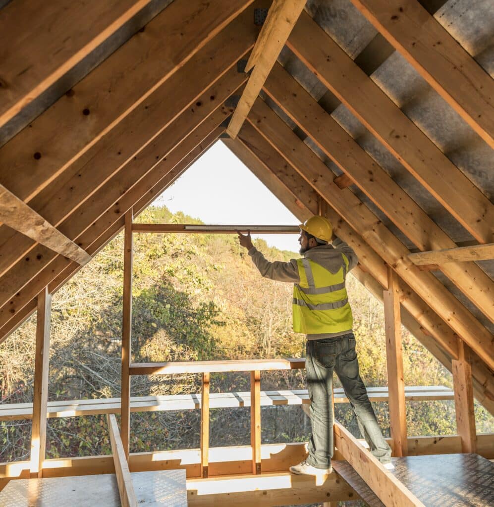 Un ouvrier travaillant le toit d'une maison à ossature bois